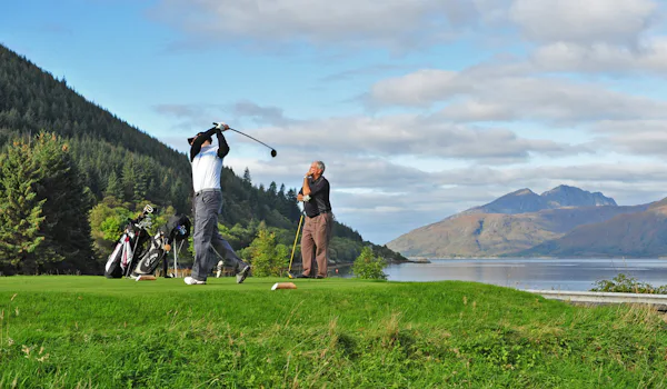 Män spelar golf på en vackert belägen golfbana.