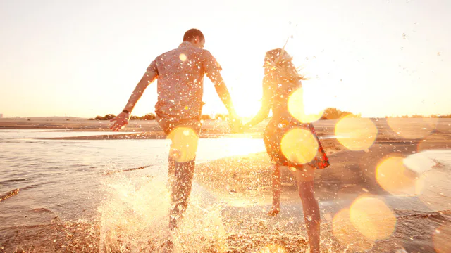 Par springer i vattenbrynet i solnedgången.