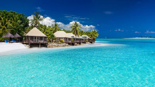 Vit sand och kristallklart ljusblått vatten