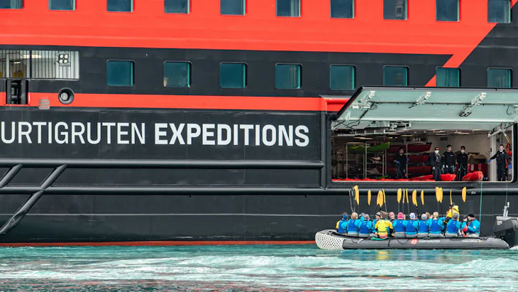 Gäster kliver ombord på en zodiak-båt, på en kryssning med Hurtigruten Expeditions.