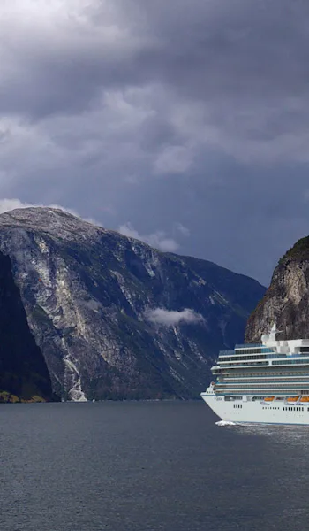 Oceania Cruises fartyg Vista omringad av höga berg på sin tur genom norska fjordar.