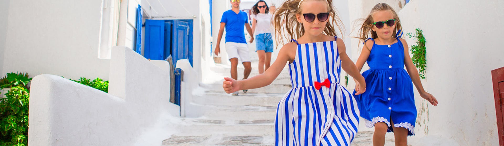 Finklädd familj bland vita hus på Mykonos i Grekland.