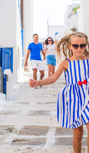 Finklädd familj bland vita hus på Mykonos i Grekland.