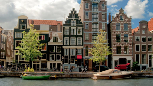Vackra byggnader längs en kanal i Amsterdam, Nederländerna.